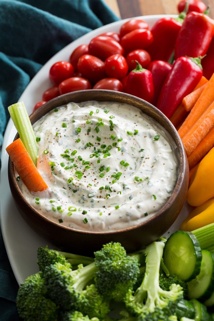 a white plate topped with vegetables and dip