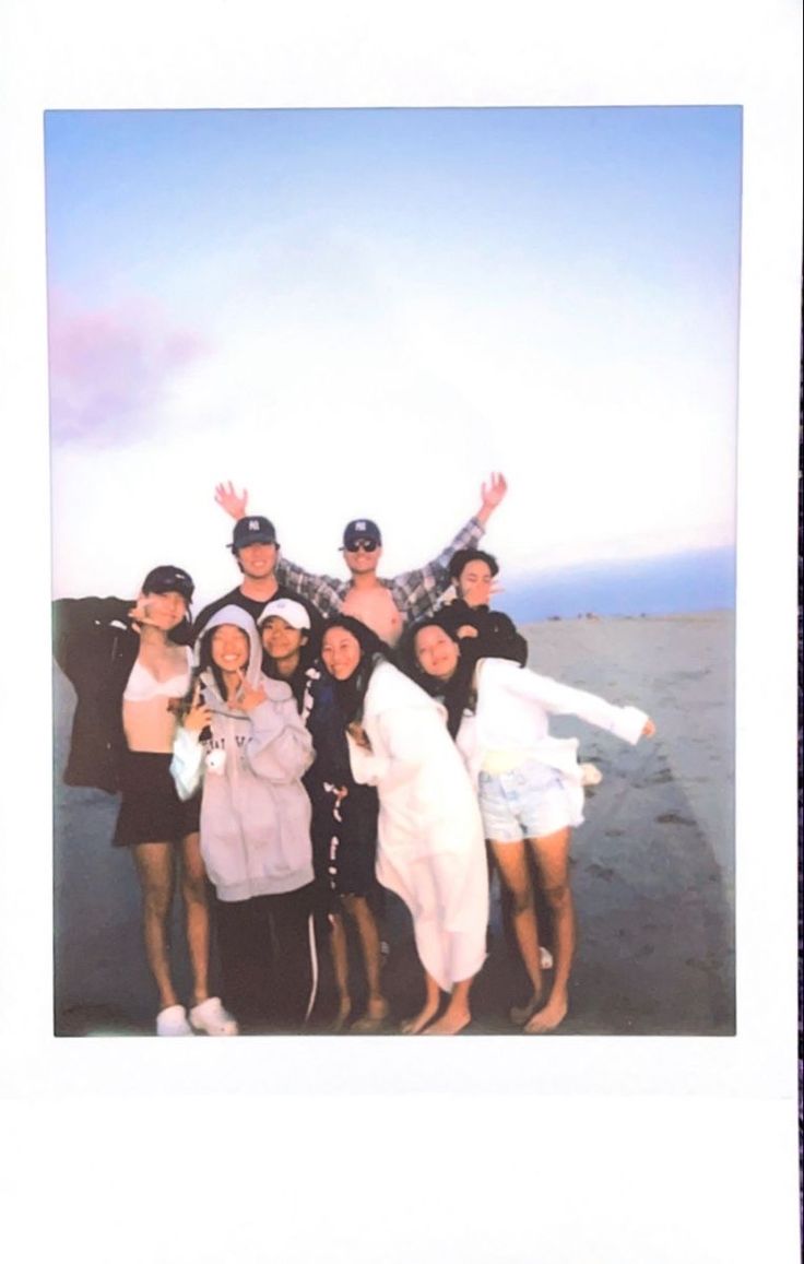 a group of people standing next to each other in front of a blue and white sky