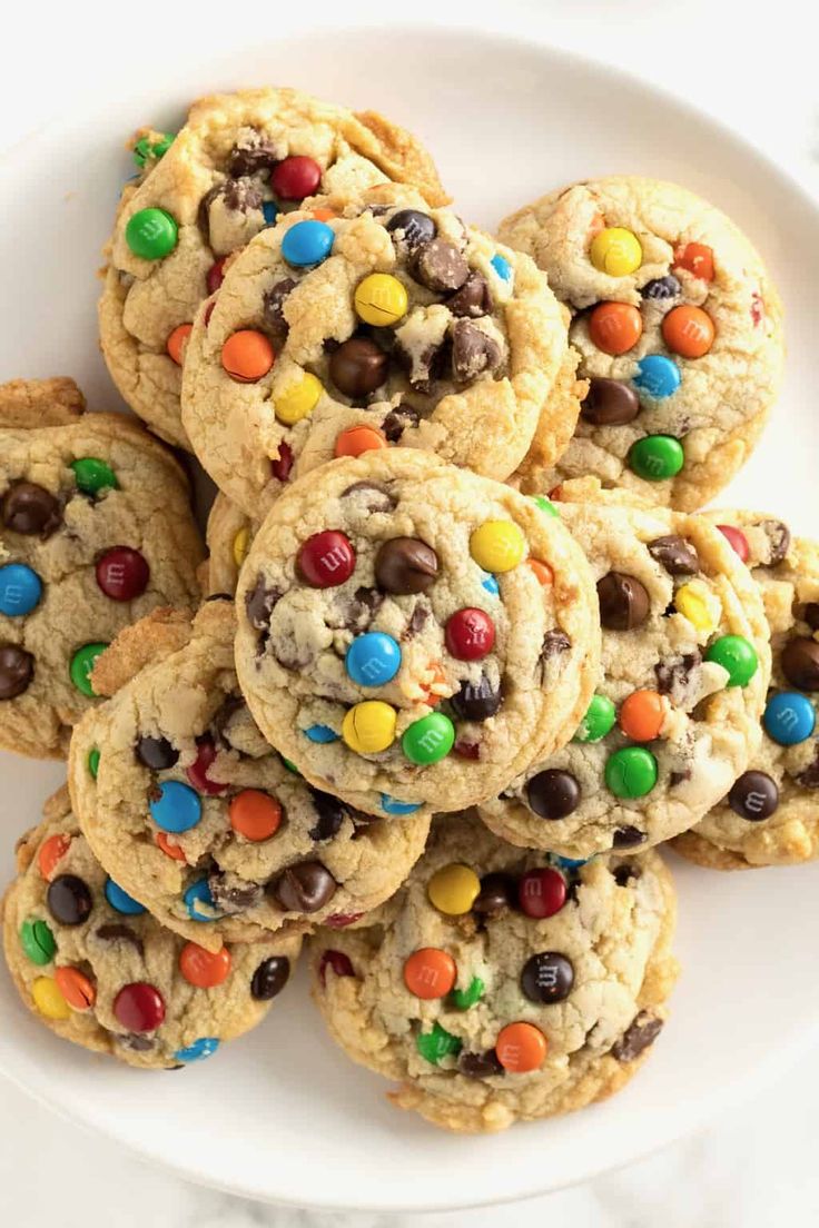 a white plate topped with cookies covered in m & m's and chocolate chips