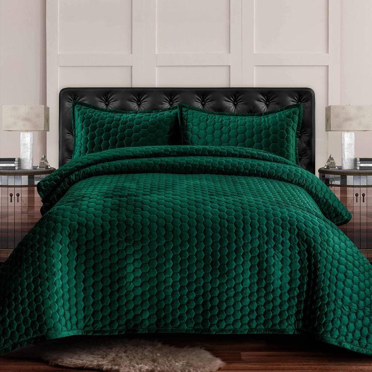 a bed with green bedspread and pillows