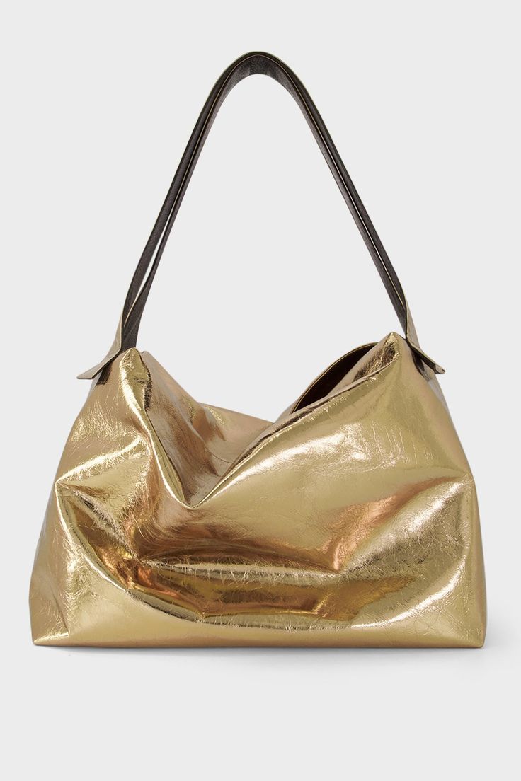 A large metallic gold shoulder bag with two long handles. The handbag is designed as a carry-all travel bag made of fine Italian leather. Metallic Tote Shoulder Bag For Formal Occasions, Metallic Double Handle Bags For Evening, Elegant Metallic Shoulder Bag For Everyday Use, Metallic Elegant Shoulder Bag For Everyday, Elegant Everyday Metallic Shoulder Bag, Gold Soft Leather Hobo Bag For Daily Use, Metallic Shoulder Bag For Everyday Use, Gold Soft Leather Satchel Hobo Bag, Modern Gold Bucket Bag For Everyday