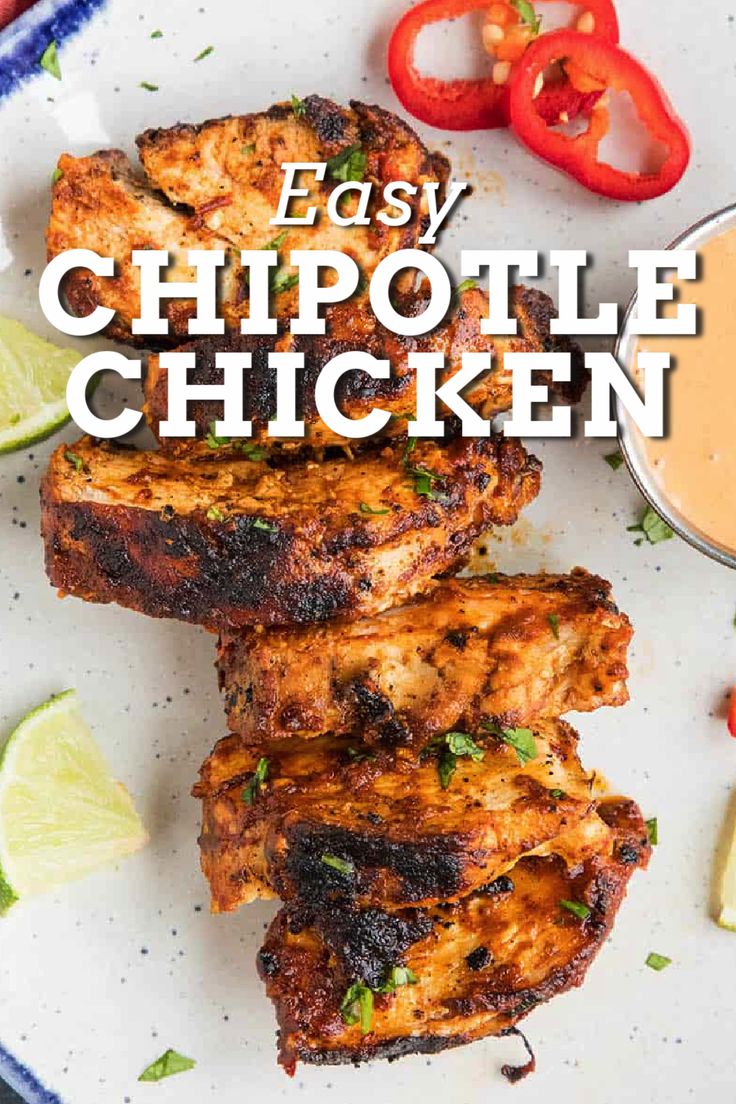 easy chipotle chicken on a plate with limes and tomatoes