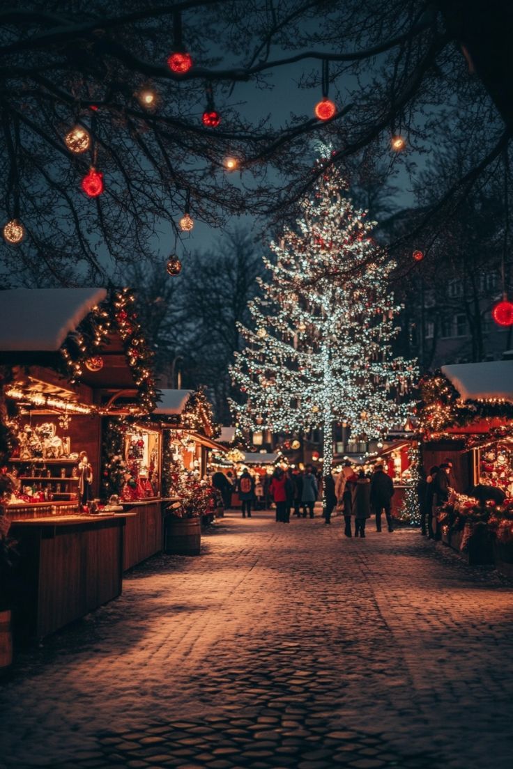 people are walking through an outdoor christmas market