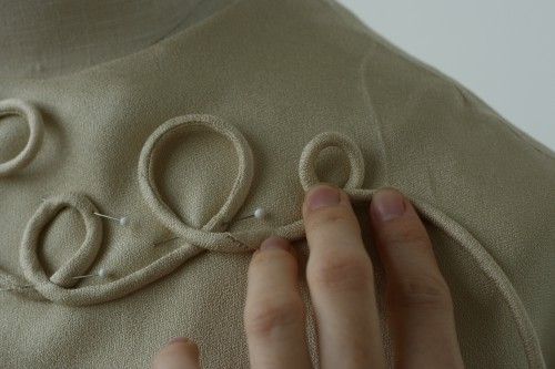 a woman is stitching the letters on her shirt