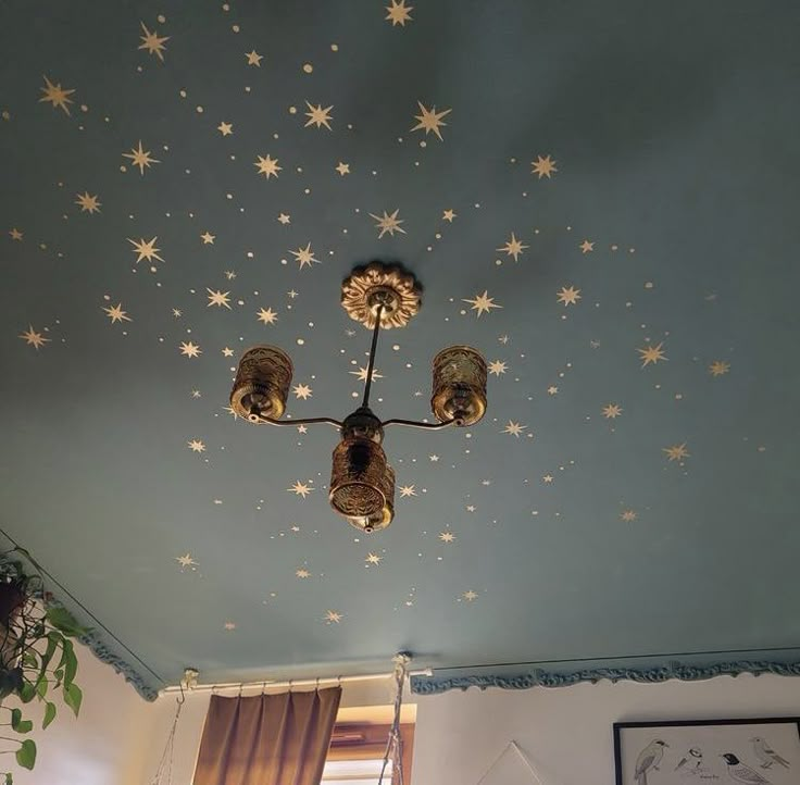 a ceiling with stars painted on it and two lights hanging from the ceiling above them