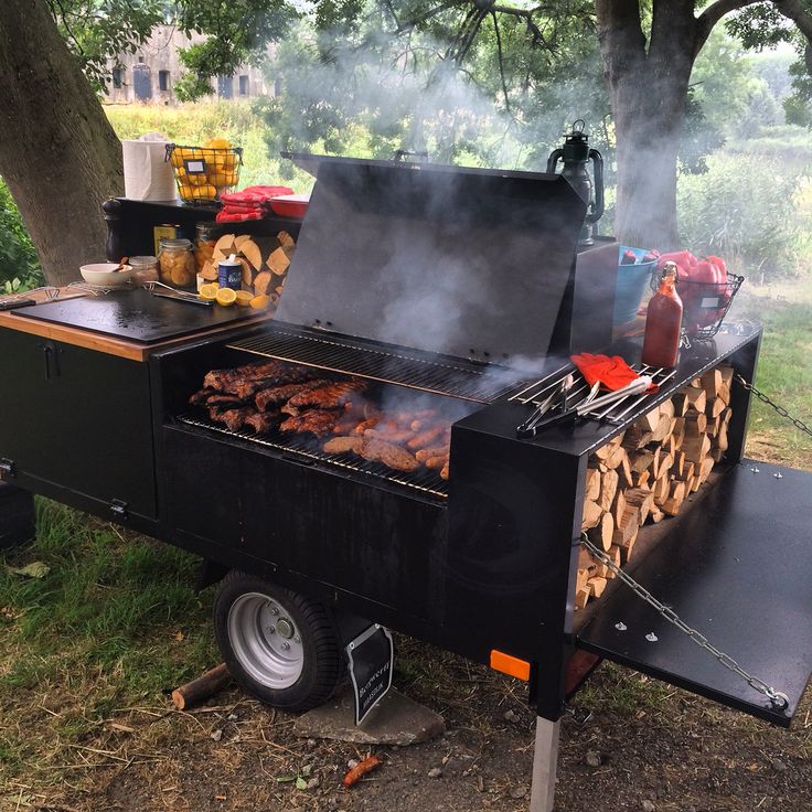 an outdoor bbq grill with lots of food cooking on it's burners