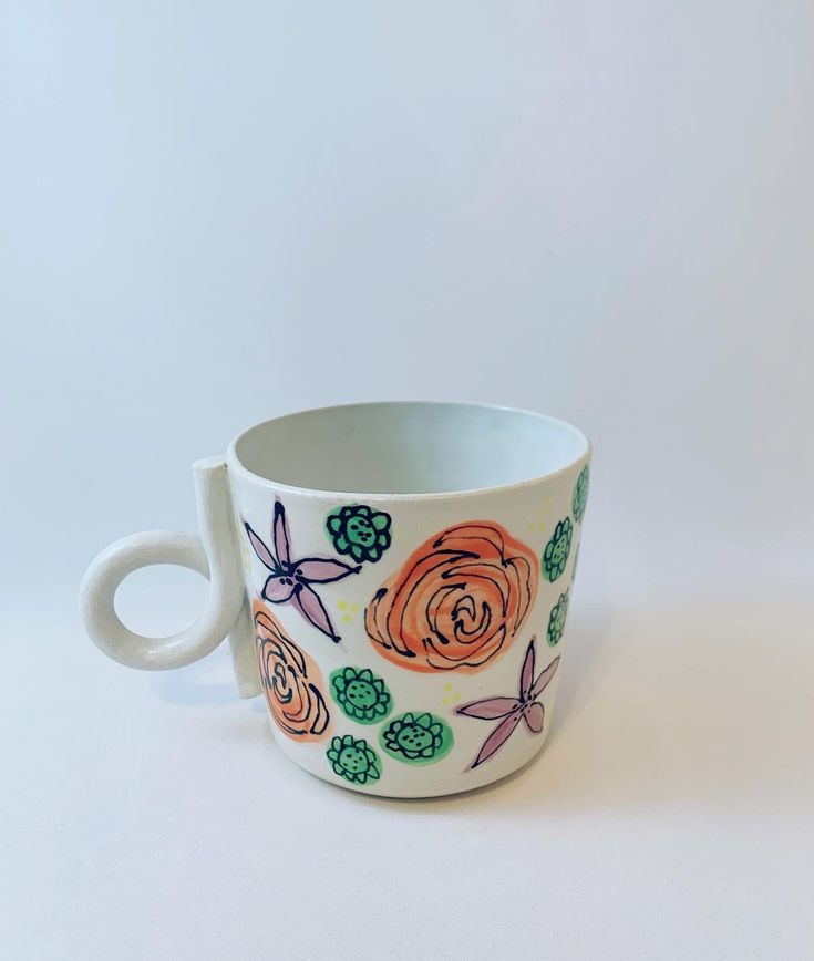 a coffee cup with flowers painted on it