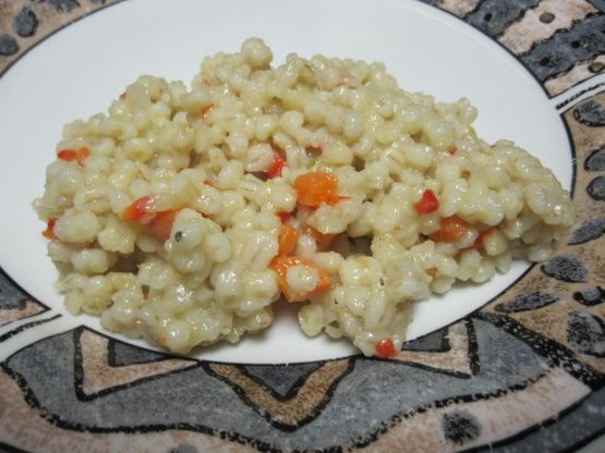 a white plate topped with macaroni and cheese on top of a patterned table cloth