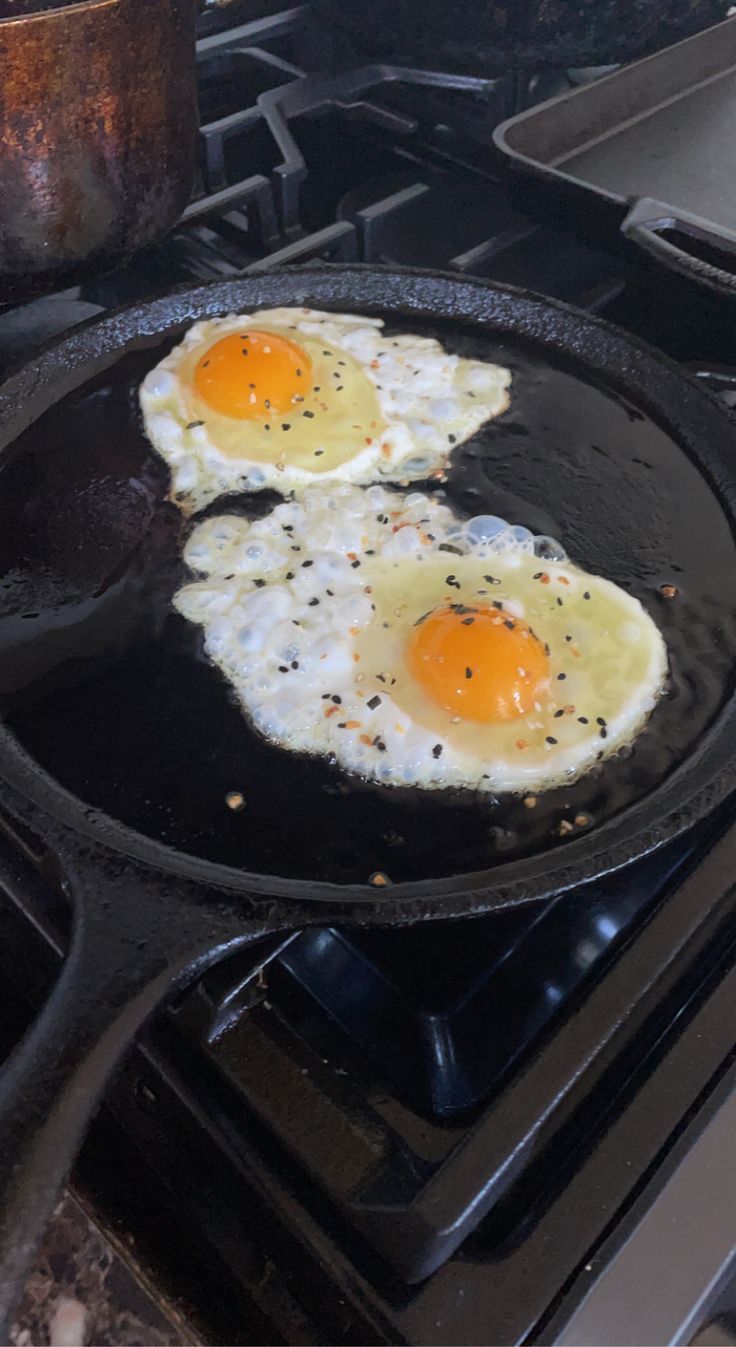 two fried eggs are in a pan on the stove