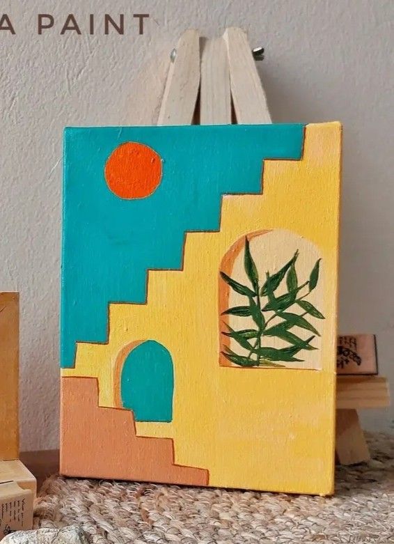 a small painting is sitting on a table next to some wood blocks and a wooden block