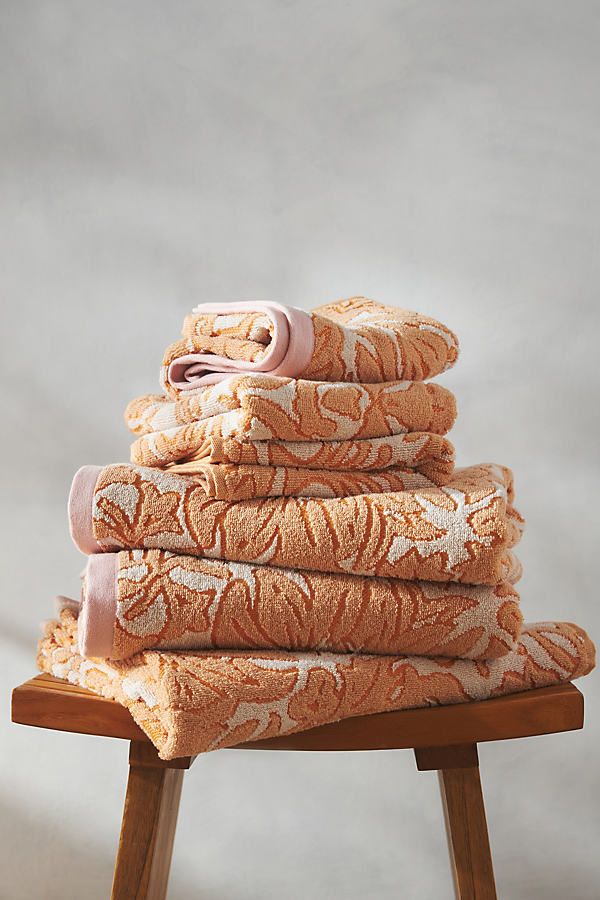 a stack of towels sitting on top of a wooden stool