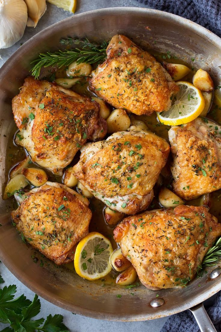 chicken thighs with lemons and herbs in a pan