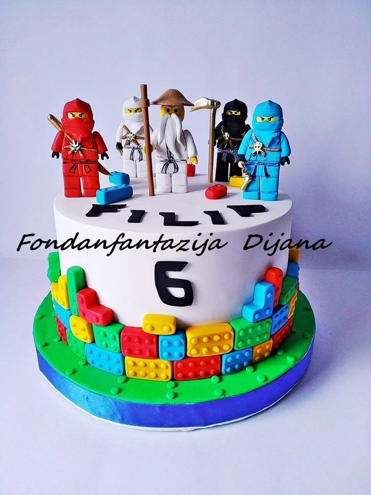 a birthday cake with legos on it and the number six spelled out in spanish