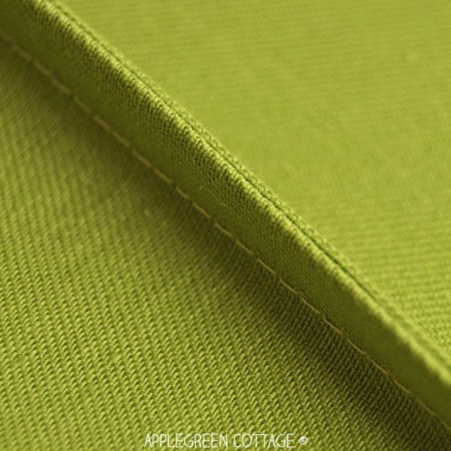 an apple green fabric with white stitching