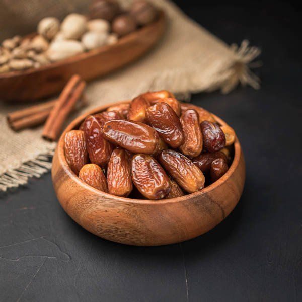 some nuts are in a wooden bowl on a table