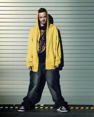 a man standing in front of a jail cell with his hands on his hips and wearing a yellow hoodie