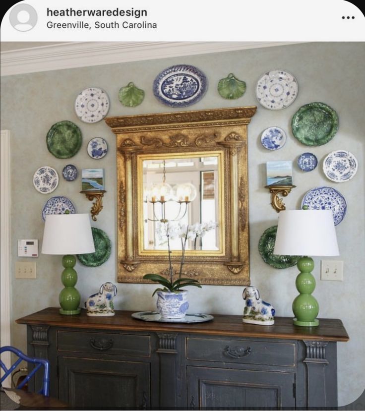 a room with plates on the wall and a large mirror above it that is decorated in blue and green