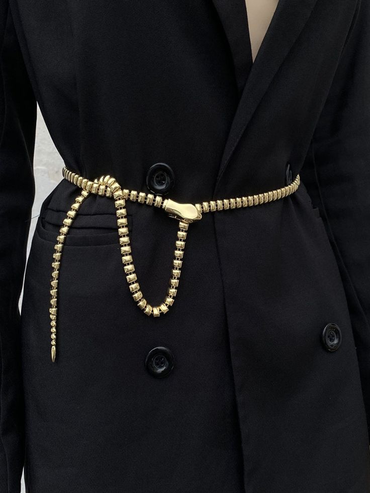 a person wearing a black suit and gold beaded belt with buttons on the waist