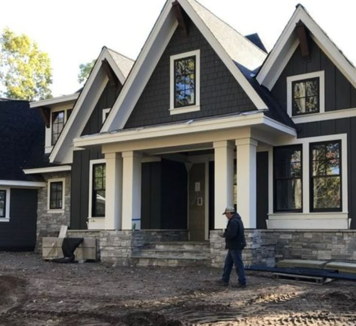 a man standing in front of a house under construction