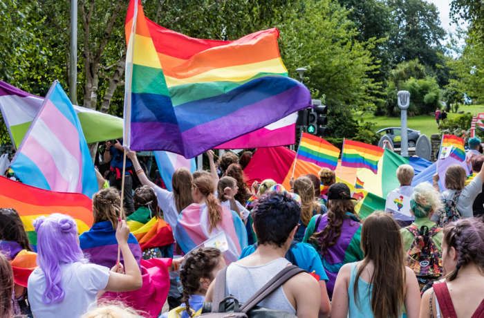 a group of people holding rainbow colored flags