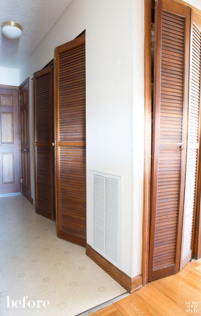 an empty room with wooden shutters on the doors and hard wood flooring in it