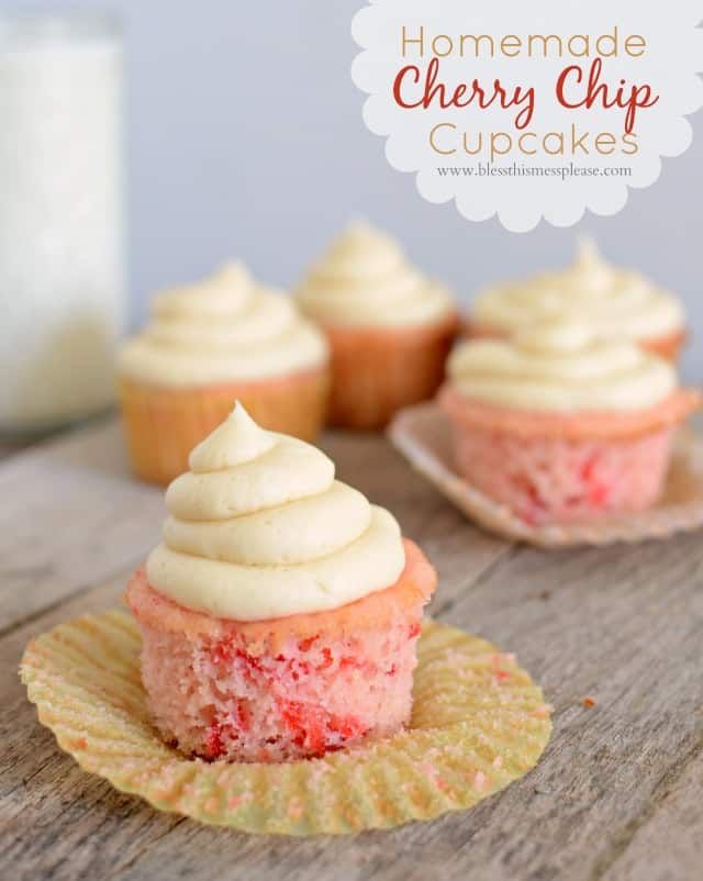 cupcakes with white frosting sitting on top of a wooden table