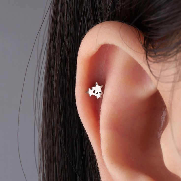 a woman's ear with a small silver star on it