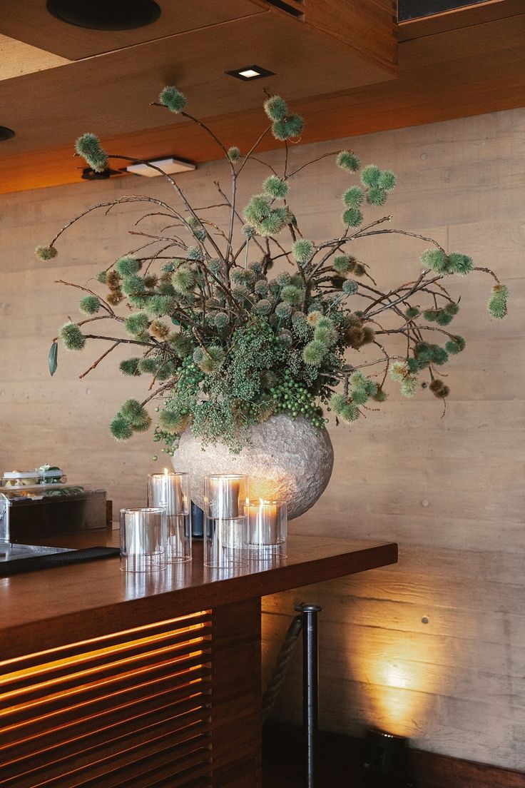 a vase filled with flowers sitting on top of a wooden table