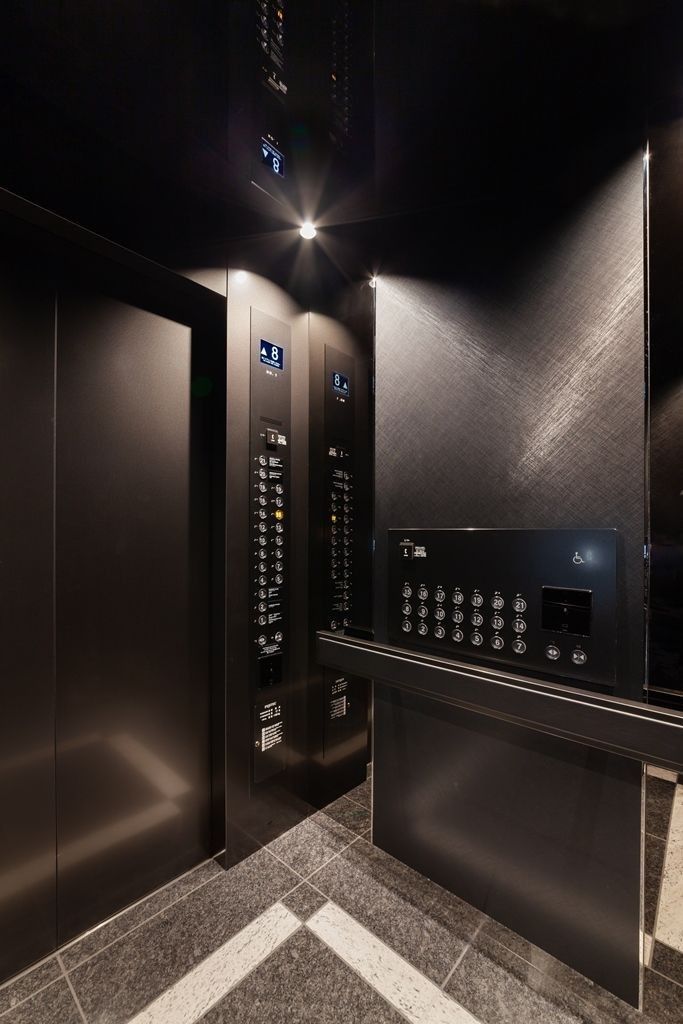 an elevator with buttons and lights on the wall next to each other in a dark room