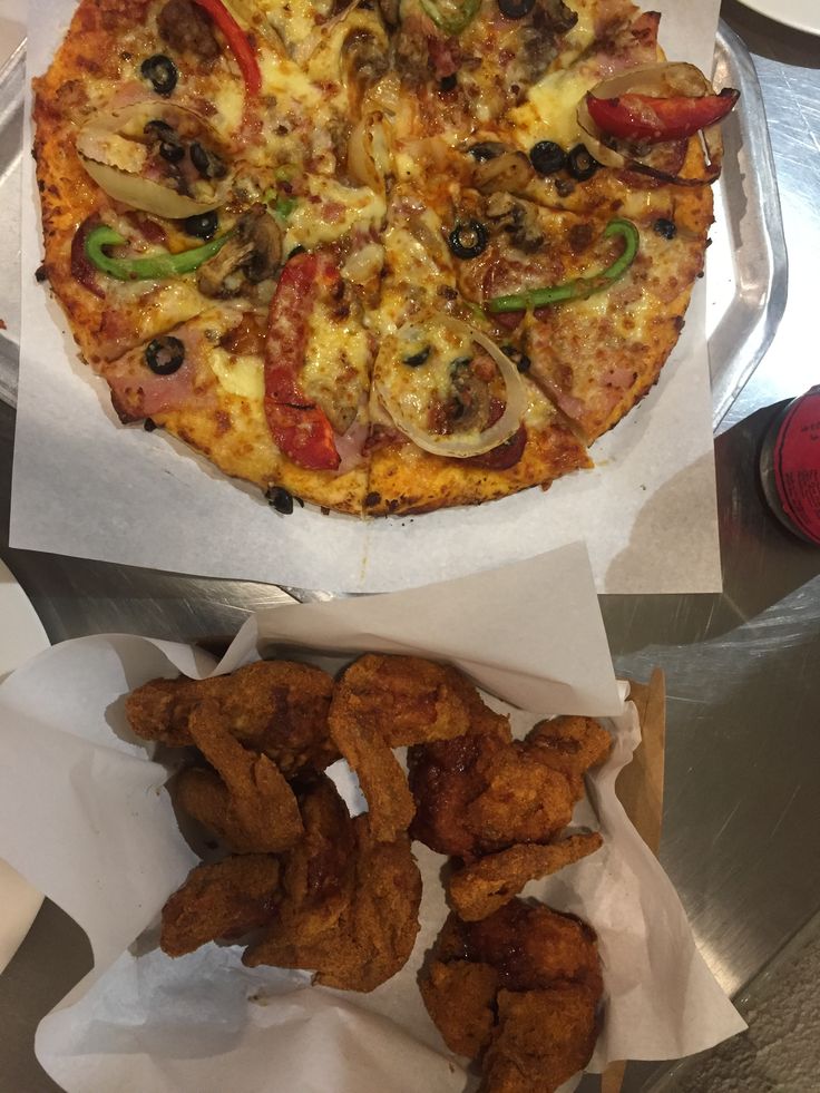 a pizza and some onion rings on a table