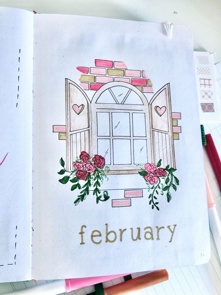 an open notebook with the words february written on it and flowers in front of a window