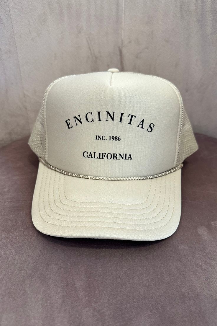 COLOR: Sand The Encinitas Trucker hat is the perfect way to show pride in your favorite city! Featuring a classic Encinitas, CA printing, mesh back, foam cap and adjustable snapback. DETAILS + CARE: 100% Polyester One size fits most Designed in Ventura, CA Jesus Wallpaper, Color Sand, Favorite City, Clothing Ideas, Color Khaki, Trucker Cap, Apparel Accessories, Trucker Hat, Mood Board