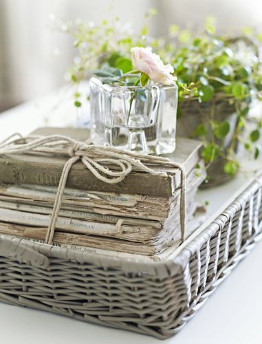 a wicker basket with flowers and books on it