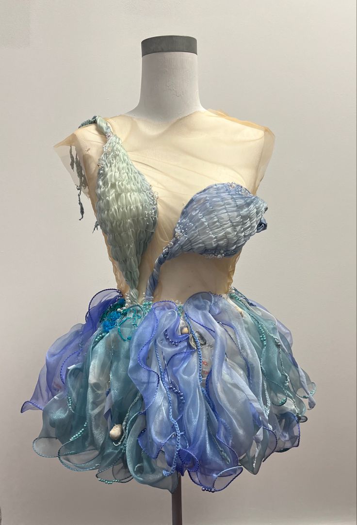 a mannequin with blue and green dress on display