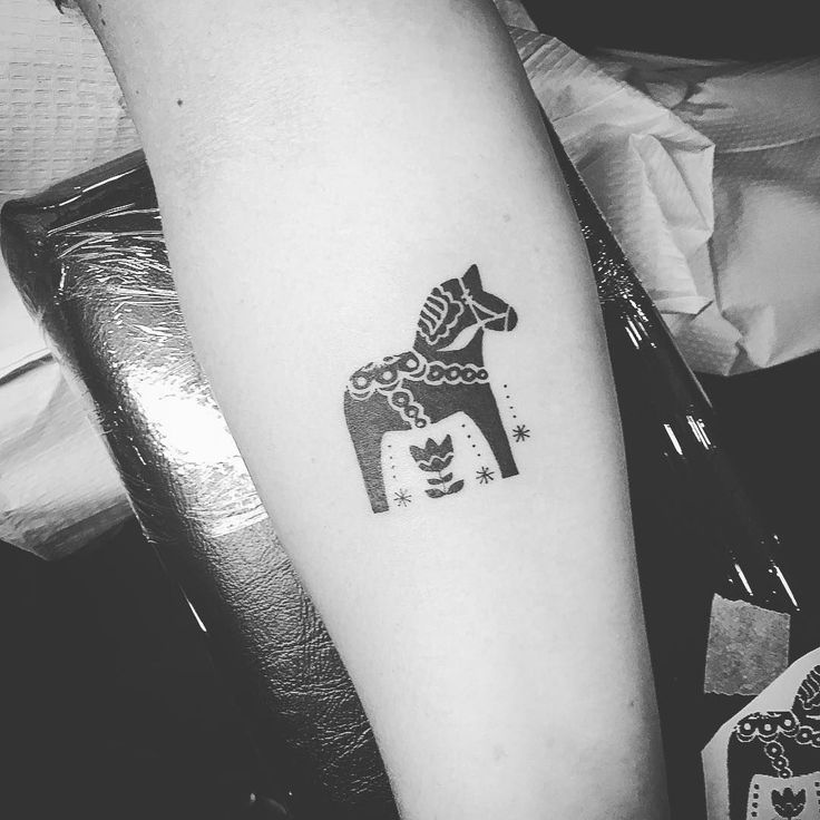 a black and white photo of a giraffe tattoo on the right arm,