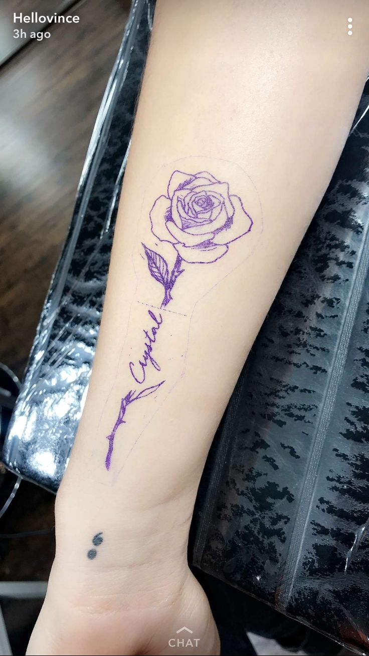 a tattoo on the arm of a woman with a rose and name written in cursive writing