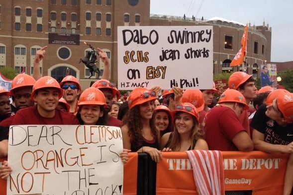 a group of people with orange hats holding signs