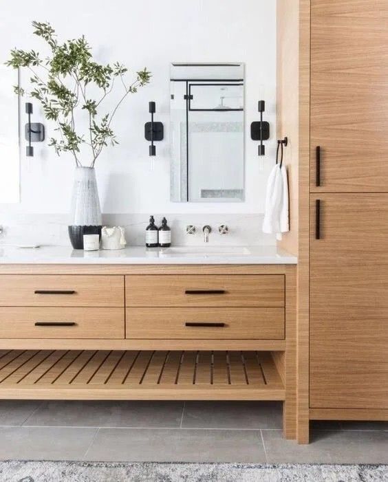 a bathroom with wooden cabinets and two sinks