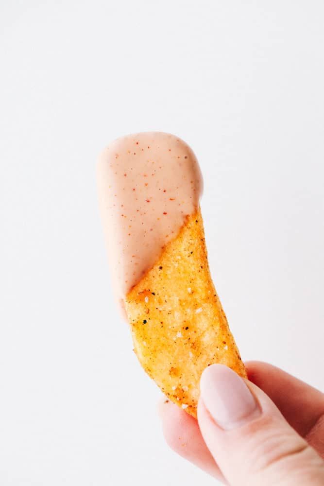 a hand holding a small cracker in it's left side, with the tip sticking out