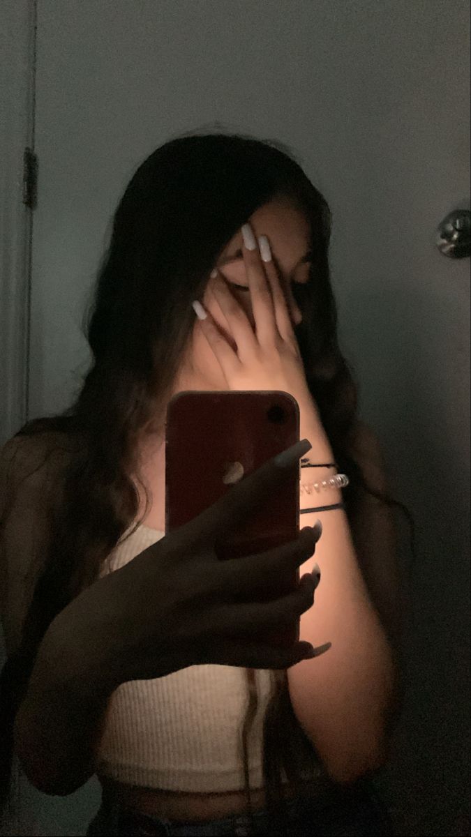 a woman looking at her cell phone in the dark