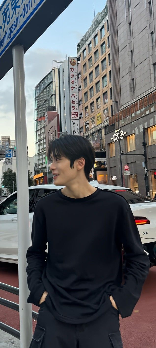 a man standing next to a street sign