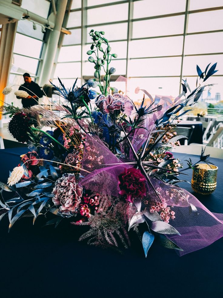 an arrangement of flowers on a table in a room