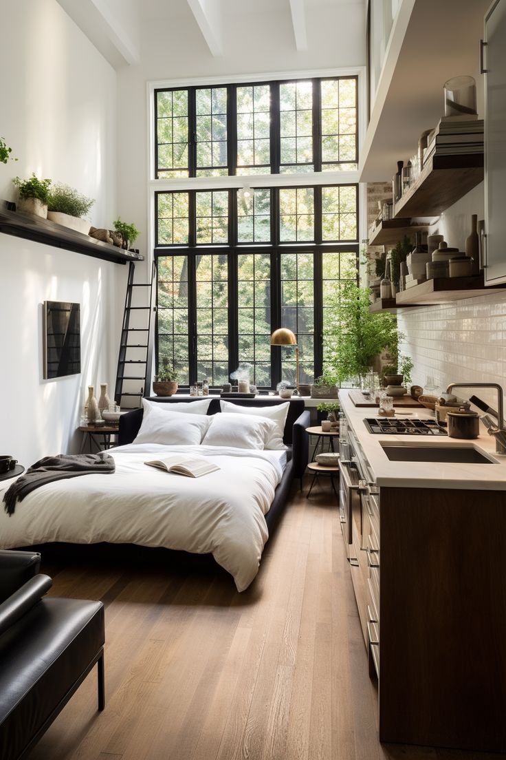 a bed sitting on top of a wooden floor next to a kitchen sink and window