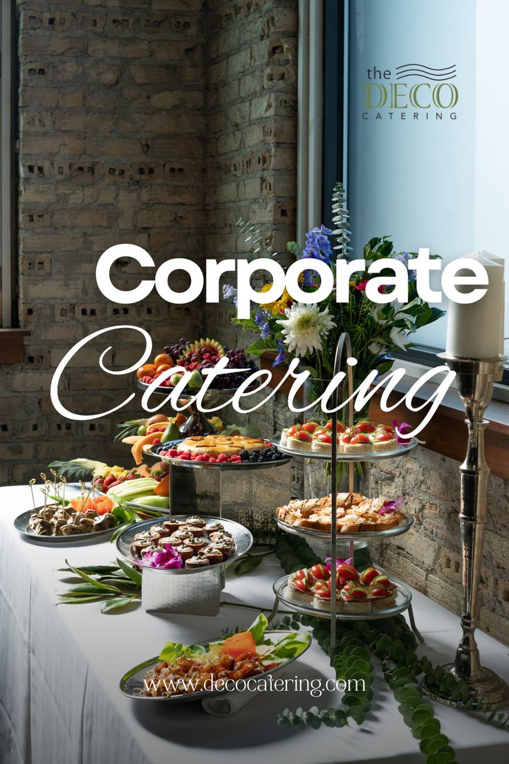 a table topped with plates of food next to a brick wall and window that says corporate catering