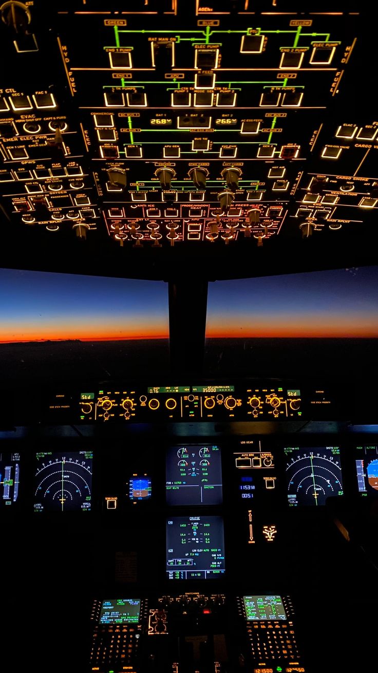 the view from inside an airplane cockpit at night with illuminated instruments and lights on it