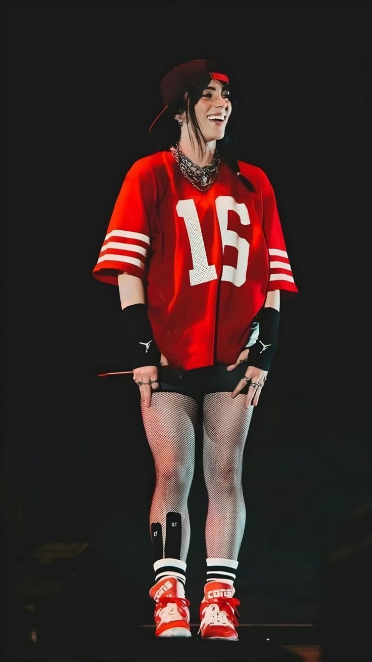 a woman in red and white outfit standing on stage with her legs spread wide open