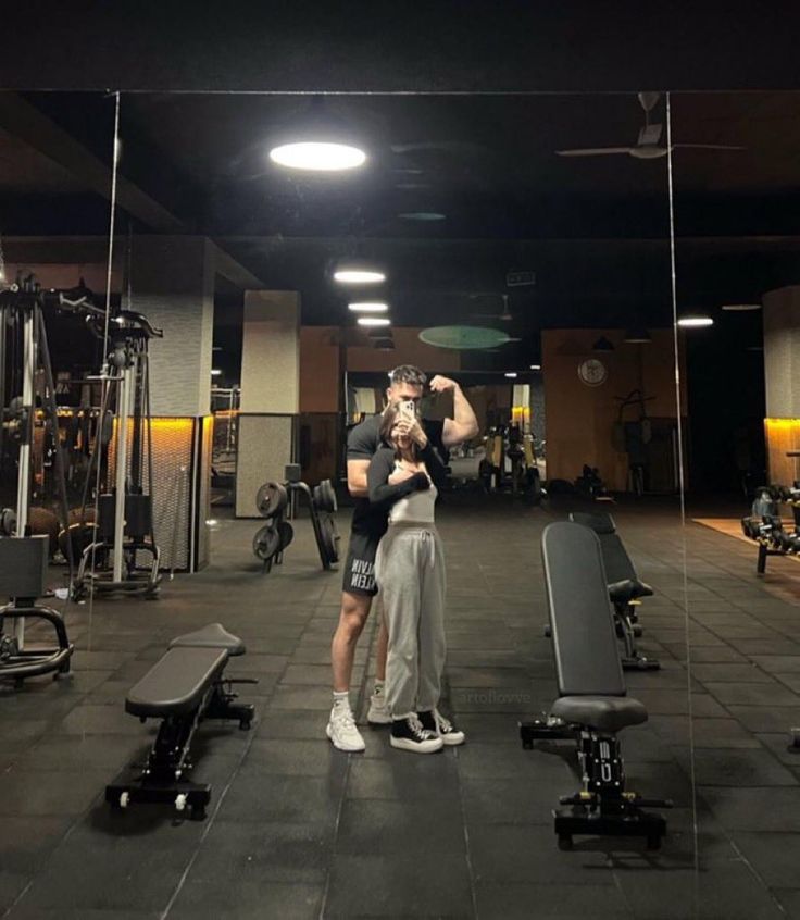 a man and woman standing in a gym holding each other