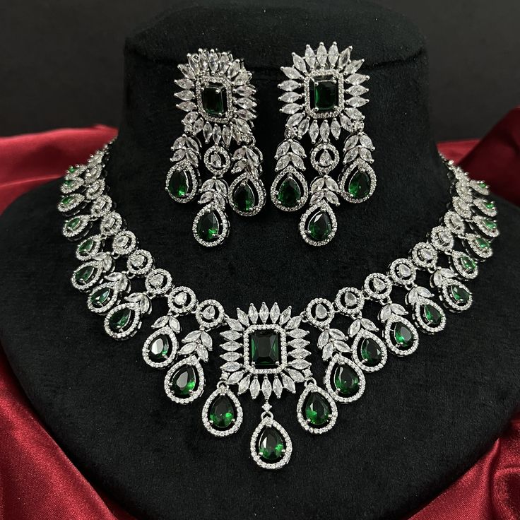 Gorgeous fine quality replica diamond and emerald green studded necklace with a white  rhodium plating and matching Earrings Item contains: Necklace and earrings AAA-quality cubic zirconia was used. Highest quality and craftsmanship Necklace Fitting is adjustable Earrings Closure: Pushback Necklace Closure: chain with Hook Green Bridal Necklace With Diamond Accents As Gift, Dazzling Green Jewelry Sets For Anniversary, Traditional Green Diamond Necklace, Formal Green Bridal Necklace With Diamond Accents, Traditional Green Hallmarked Bridal Necklace, Traditional Emerald Jewelry Sets For Formal Occasions, Traditional Green Emerald Necklace With Diamonds, Dazzling Green Round Jewelry Sets, Fine Jewelry Green Bridal Necklace For Celebration