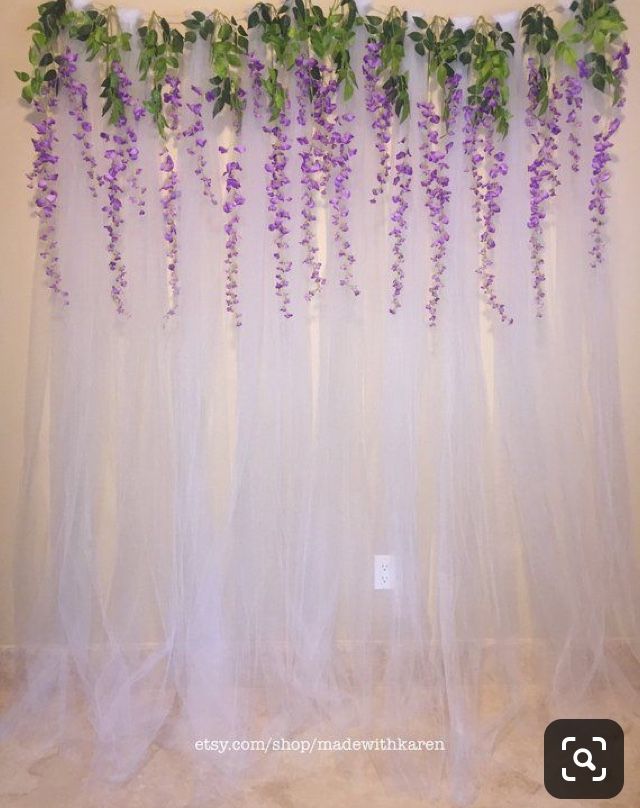 purple flowers are growing on the sheer curtain