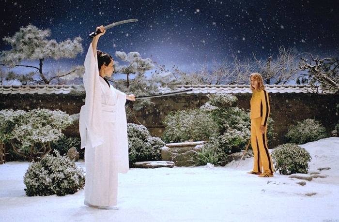 two women dressed in ancient chinese clothing holding swords and pointing them to the sky with snow falling on them